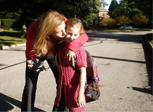 Mother Kissing Daughter Before Going Back to School
