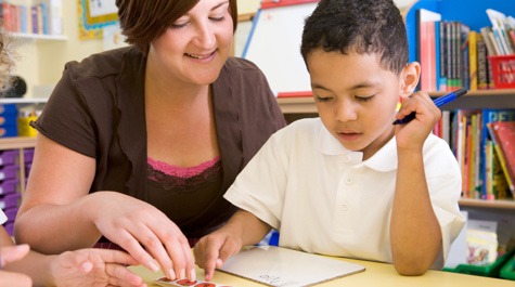 Woman helping boy read